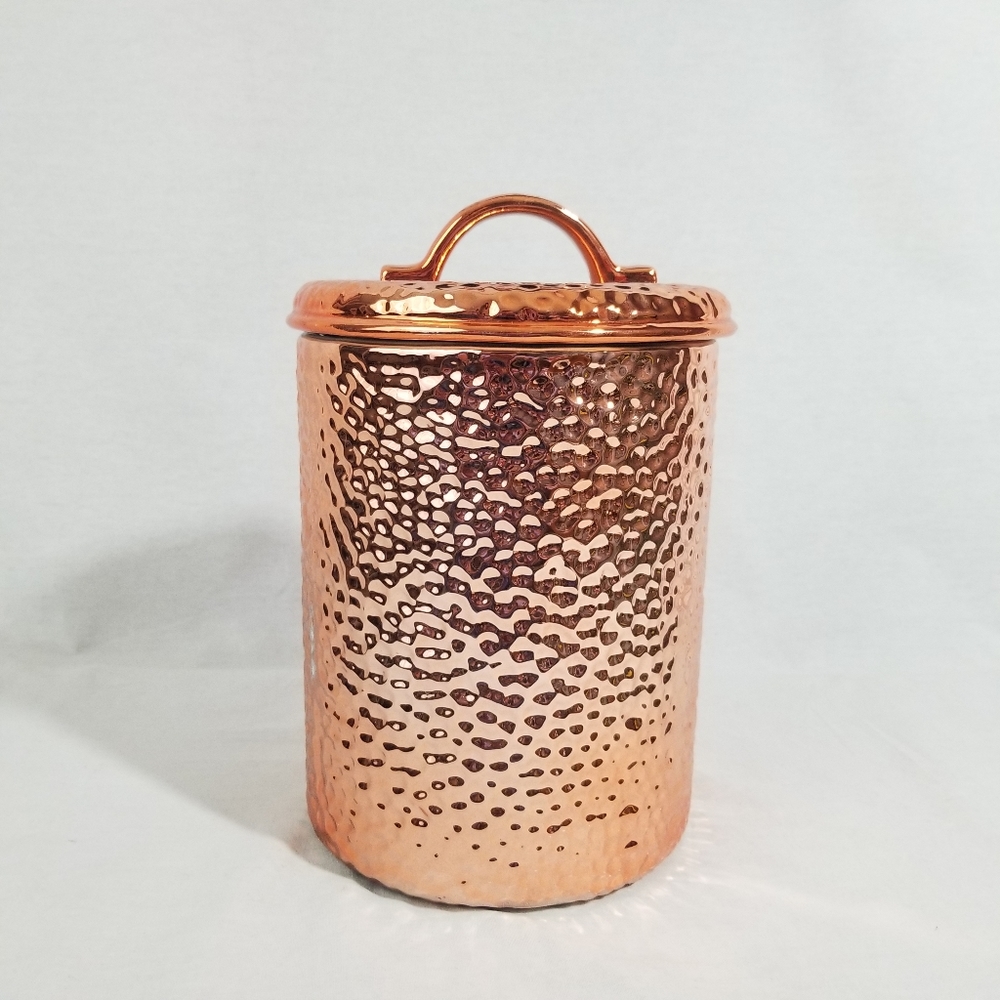 Rustic hammered copper and ceramic food storage container.